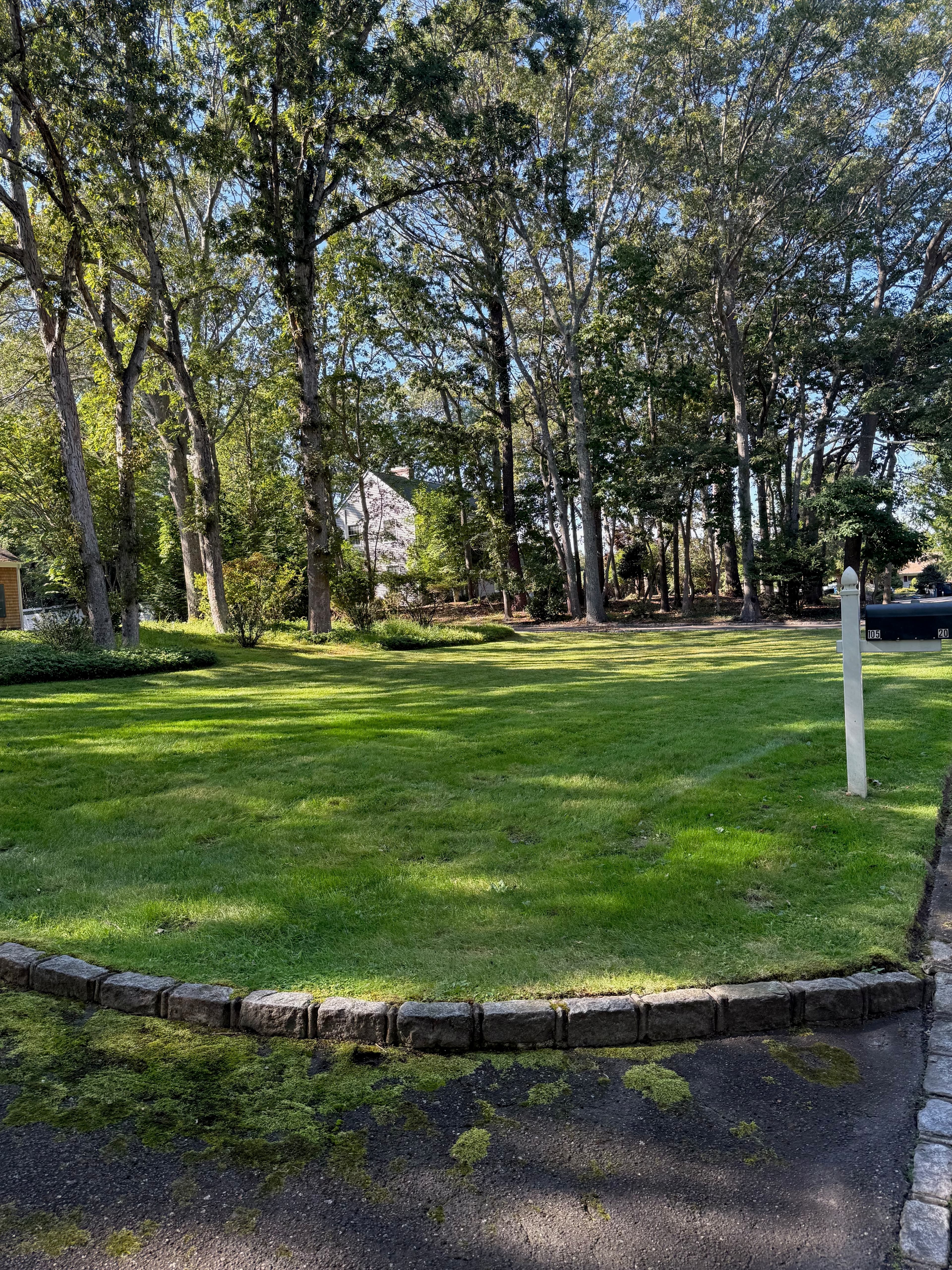Maintained lawn with stone curbing after spring cleanup